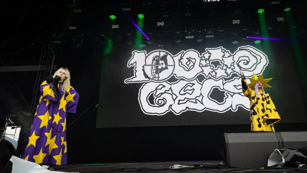 100 gecs performing on stage in star-patterned costumes