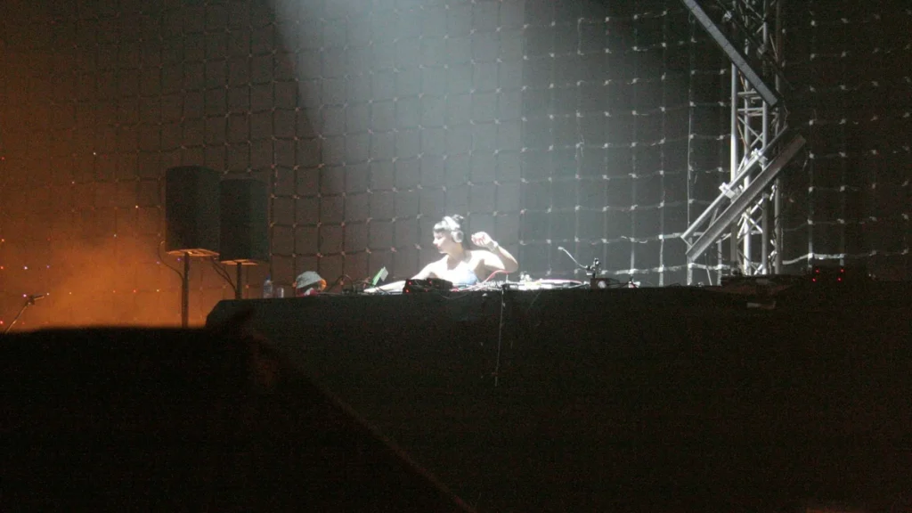 Miss Kittin performing behind decks on a large stage