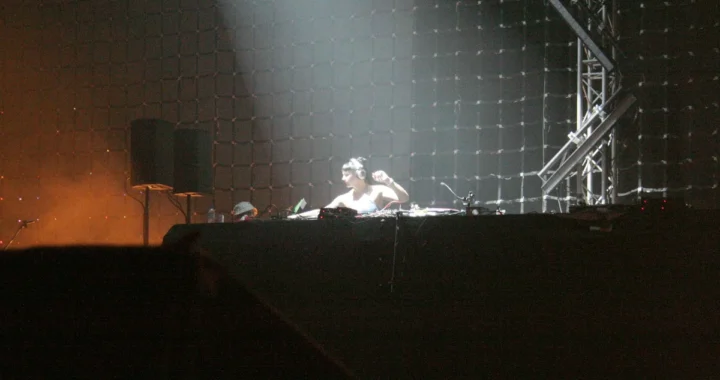 Miss Kittin performing behind decks on a large stage