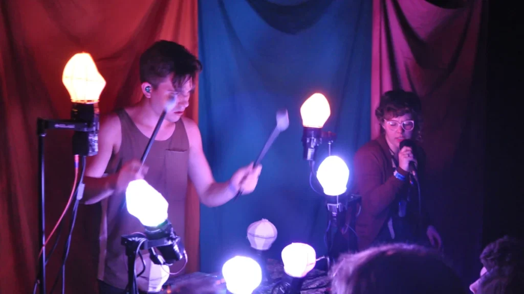 Purity Ring performing live with their illuminated custom stage instrument